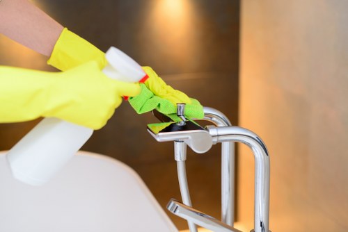 Cleaner wiping windows and frames in a renovated Acton property