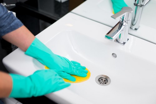 Office cleaners in Acton disinfecting shared desks and surfaces
